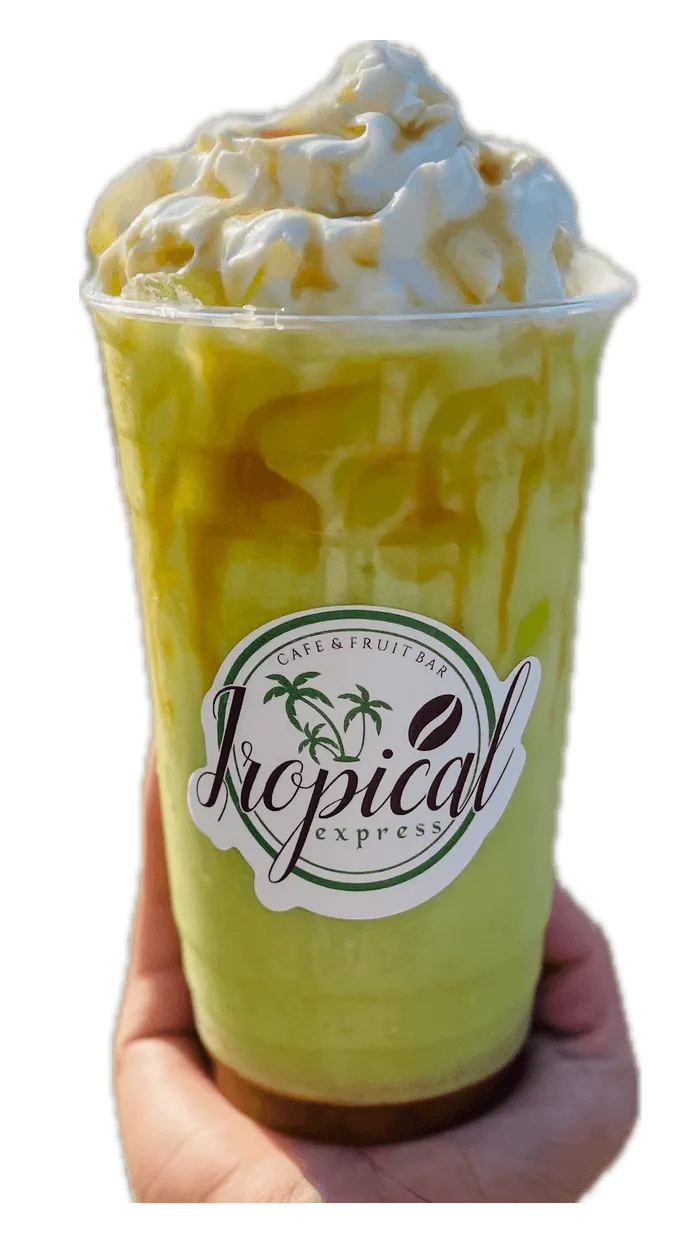 A hand holding a Tropical Express cup of Caramel Apple — a green apple drink with cream and caramel drizzle