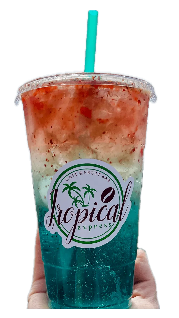 A hand holding a Tropical Express cup of Spicy Tide — a green LOTUS energy drink with cucumber, lime and pineapple, Tajín and chamoy
