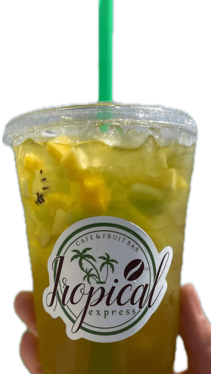 A hand holding a Tropical Express cup of Tiki Twist — a mango and kiwi drink topped with fresh fruit